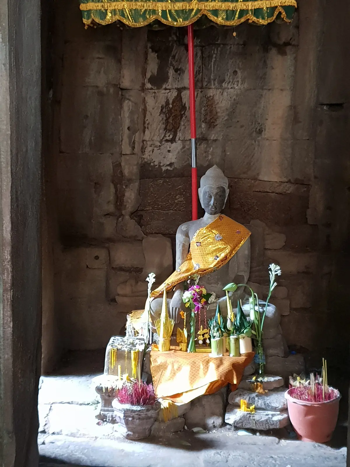 Buddhafigur im Licht eines alten Tempeldurchgangs