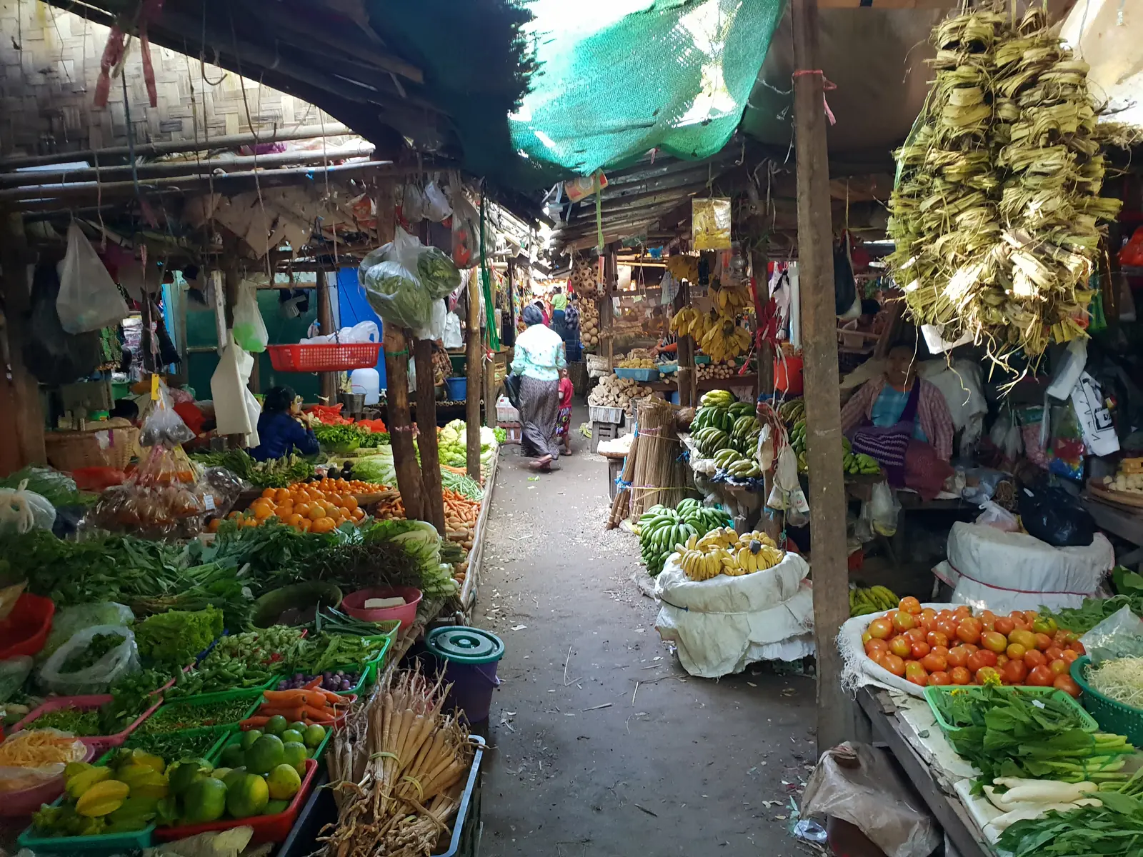 Schmaler Marktgang mit Obst, Gemüse und alltäglichem Leben in Kampot